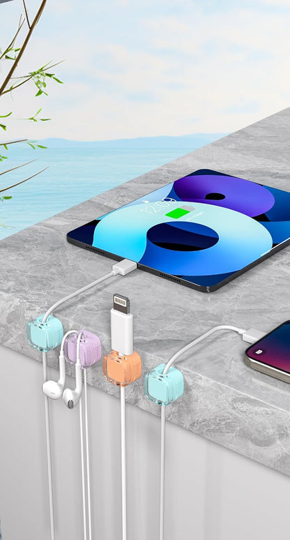 Magnetic cable clips holding a phone charging cable on a desktop